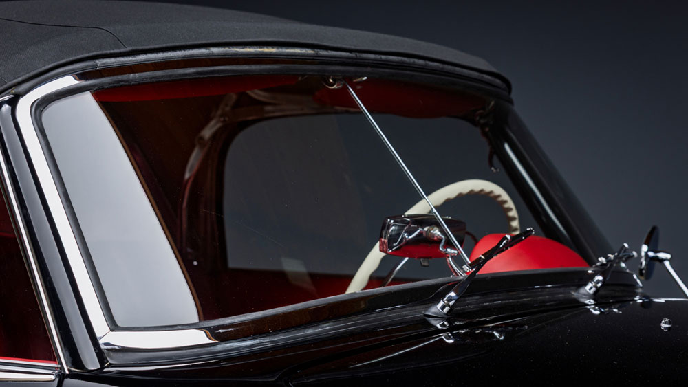Convertible top mechanism being inspected by technician for repair